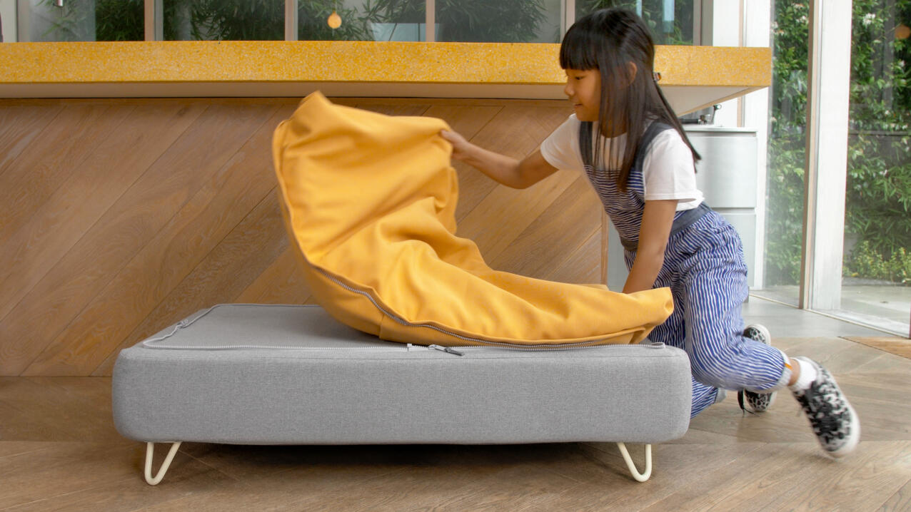 Bambina che rimuove un beanbag giallo Topology topper