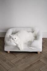 Un gatto bianco che si Gode il comfort della sua cuccia bianca