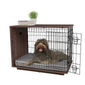 Un cane seduto dentro una cassa per cani Omlet Fido Studio noce.