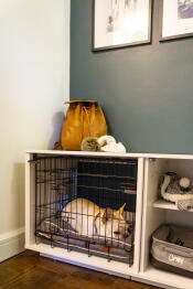 Un cane bianco addormentato dentro un Fido Nook con un armadio e una cassa