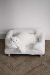 Un gatto bianco che si Gode il comfort della sua cuccia bianca