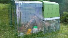 Un pollaio verde Go up con una corsa allegata e una copertura sopra la parte superiore dietro la recinzione del pollo