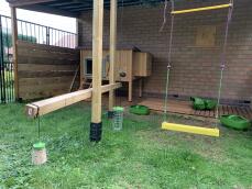 Setup giardino per i polli con un giocattolo becco, trattare caddy pollo swing, mangiatoie grub e una coop con un Autodoor