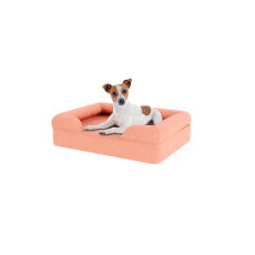 Cane seduto su piccolo letto per cani in schiuma di memoria rosa pesca