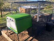 Un grande pollaio verde Cube con una pista di metallo attaccata ad esso