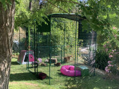 Un grande recinto per conigli in un giardino verde