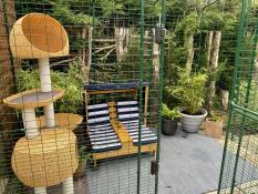 Un catio installato con sedie e molti accessori per gatti