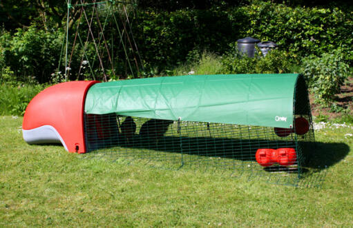 Rosso Eglu Classic pollaio con corsa e copertura verde a tutta lunghezza che fornisce ombra in giardino