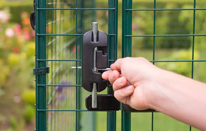 Donna che blocca il sicuro recinto Walk-In per galline