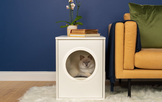 Elegante e moderno mobile cuccia per gatti con gatto bianco all'interno che sta perfettamente in casa vostra